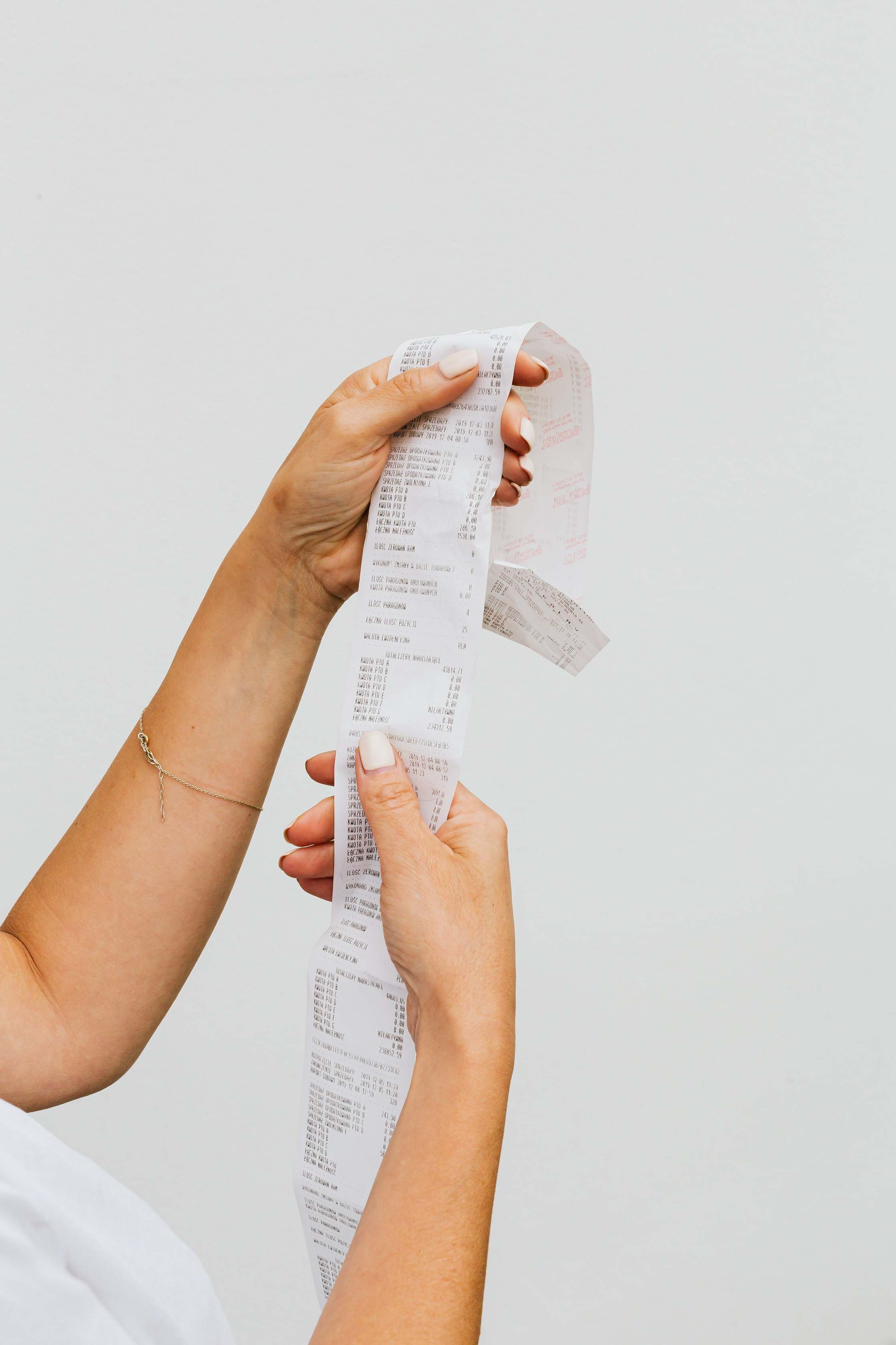 Hände an der Tastatur neben Belegen, hands holding receipt